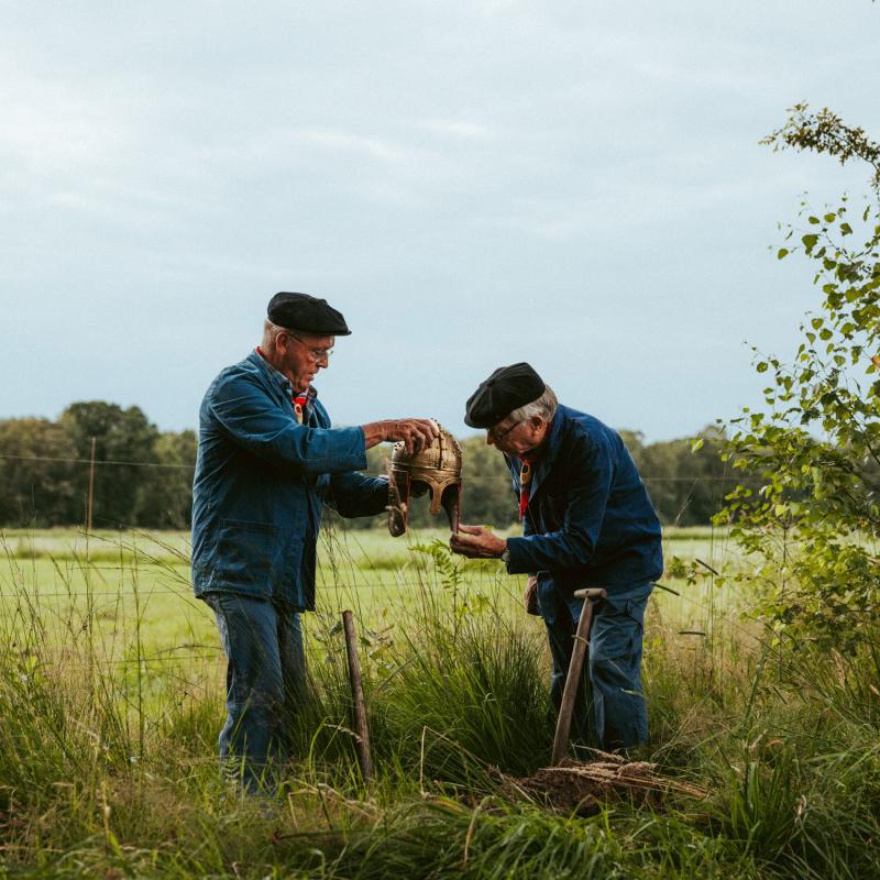 Twee turfstekers in wei met gouden helm