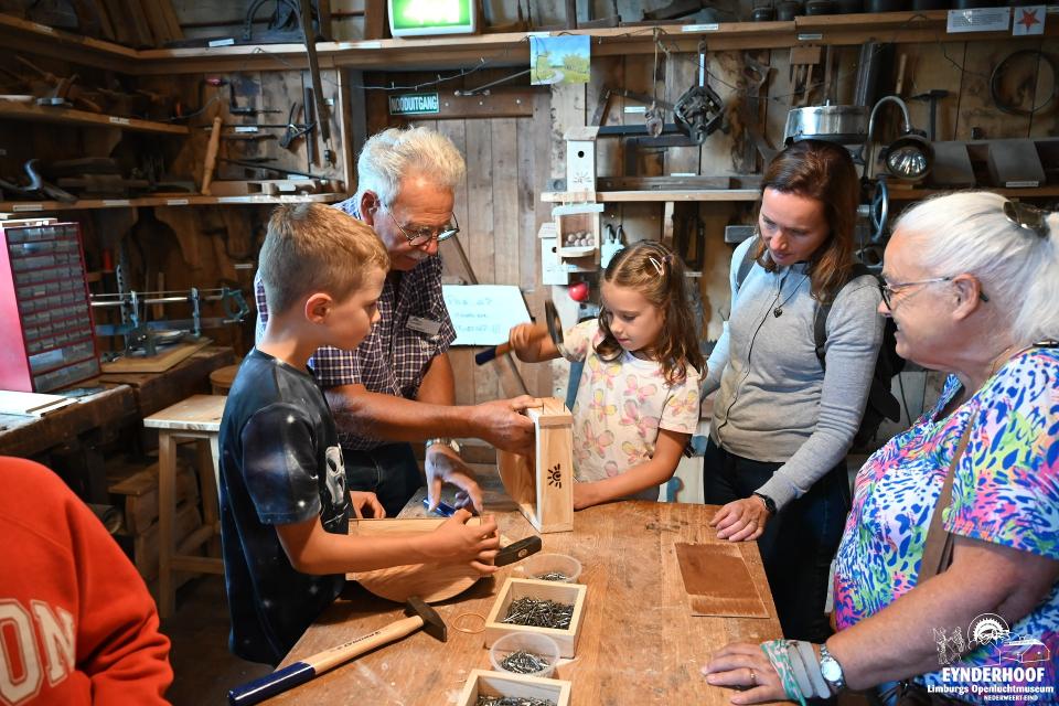 Kinderen en volwassenen knutselen met hout