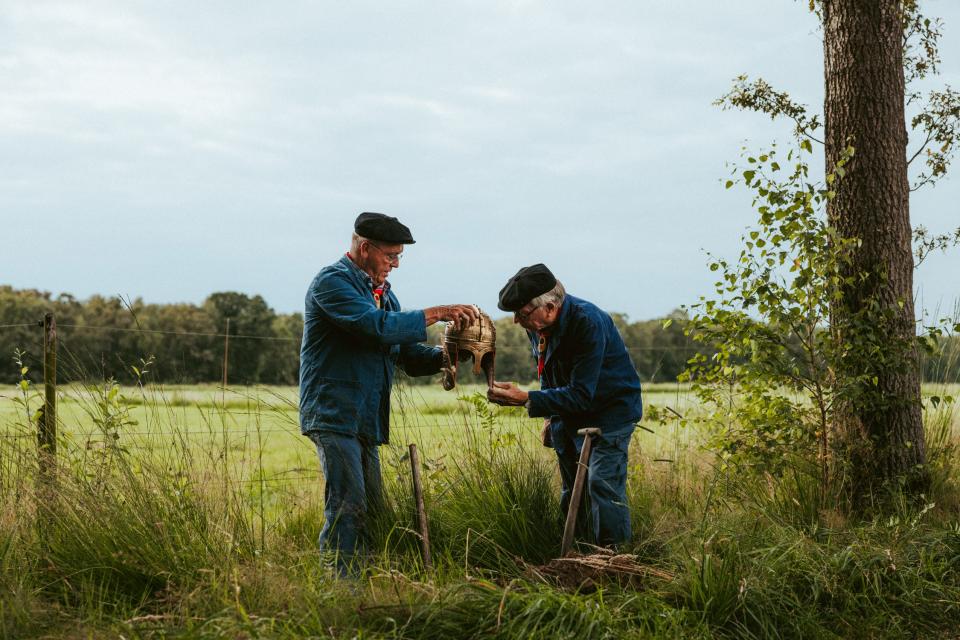 Twee turfstekers in wei met gouden helm
