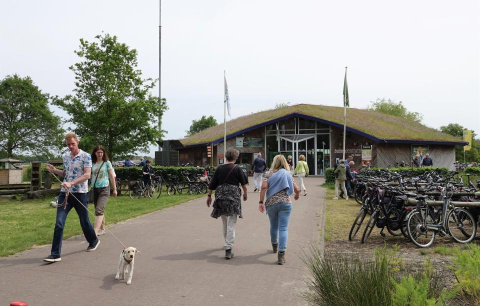 Mensen lopen naar en weg van Buitencentrum De Pelen