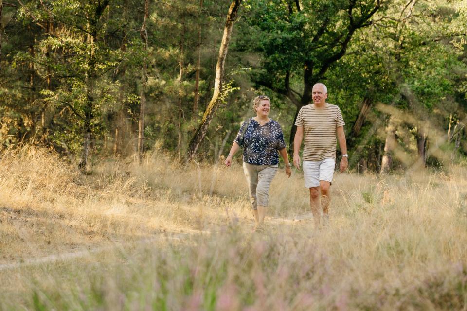 Man en vrouw wandelend in heidelandschap