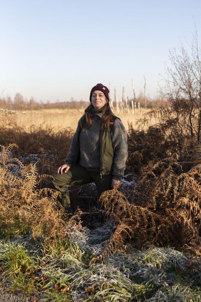 Vrouw met winteroutfit in landschap met varens