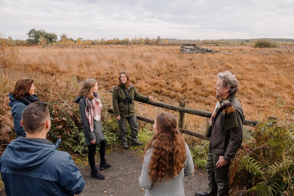 Mensen met boswachter in hoogveenlandschap
